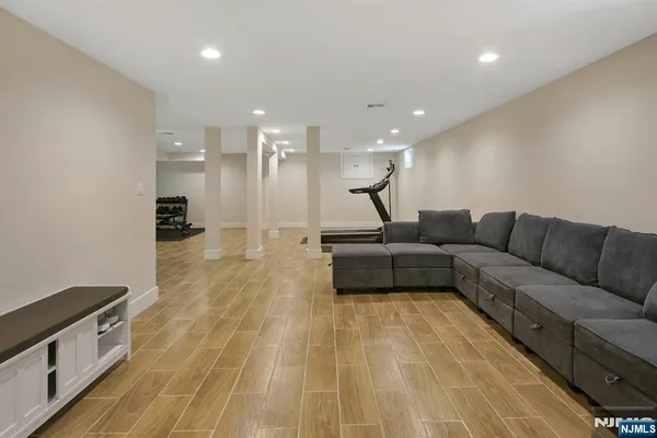 a living room with stainless steel appliances kitchen island hardwood floor and a sink