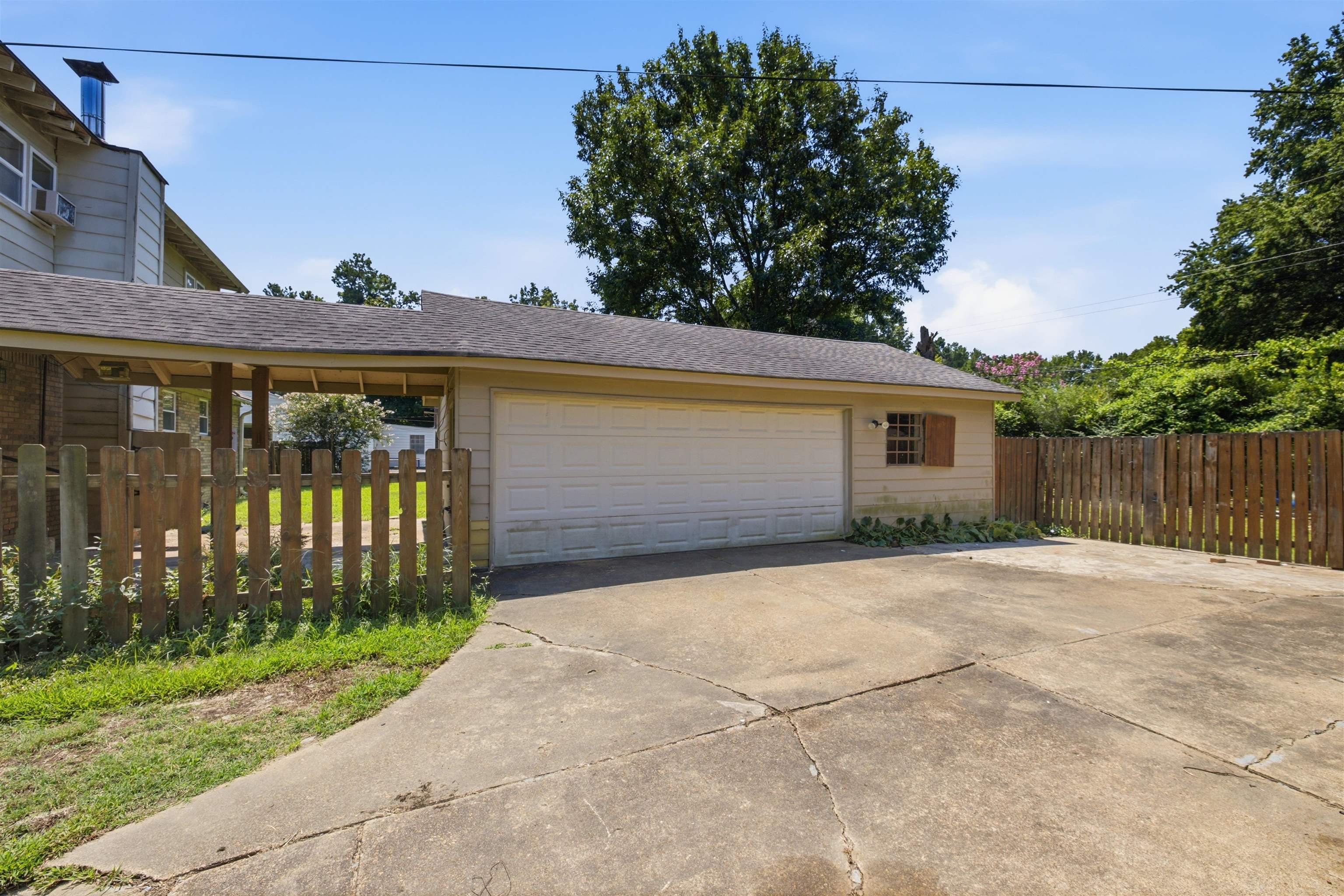 3007 Ruskin Road Bartlett, TN 38134 - Photo 37 of 37 Two-car garage with a white overhead door and an adjacent covered carport