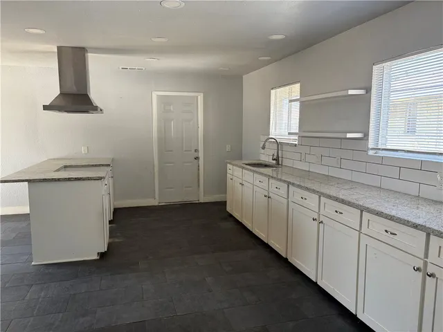 a spacious bathroom with a double vanity sink a mirror and a