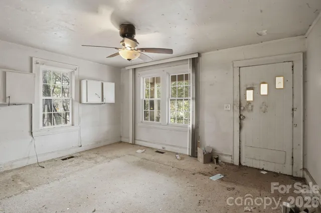 an empty room with windows and ceiling fan