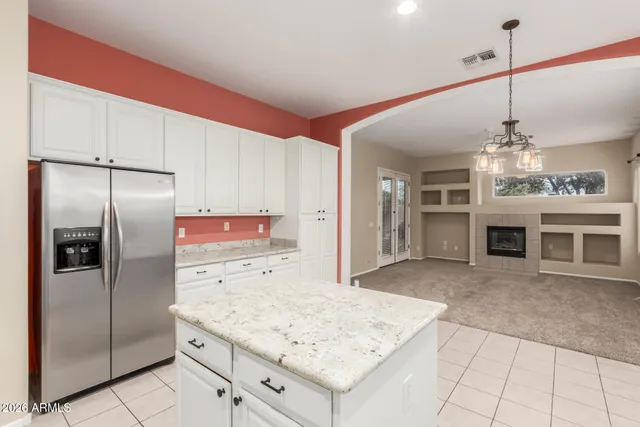 a kitchen with stainless steel appliances granite countertop a refrigerator a oven and white cabinets