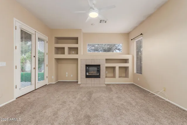 a view of an empty room with a fireplace and a window