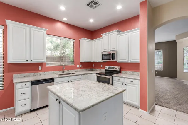 a kitchen with stainless steel appliances granite countertop a sink stove and cabinets