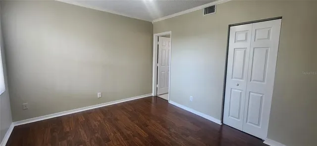 an empty room with wooden floor and closet