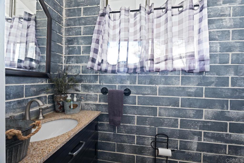 812 Sharon Way El Cajon, CA 92020 - Photo 31 of 65 a bathroom with a granite countertop sink a mirror and shower