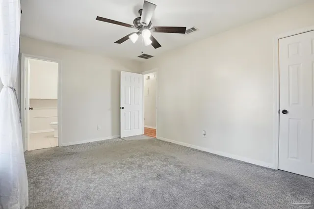 an empty room with a ceiling fan and a window