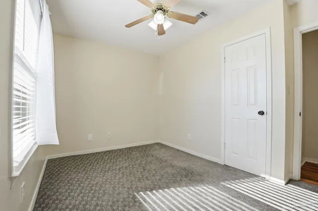 a view of a room with a window and ceiling fan