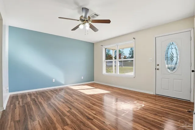 a view of empty room with wooden floor