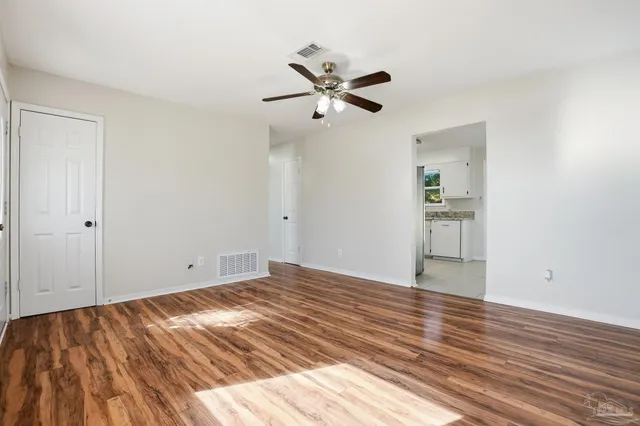 a view of empty room with wooden floor