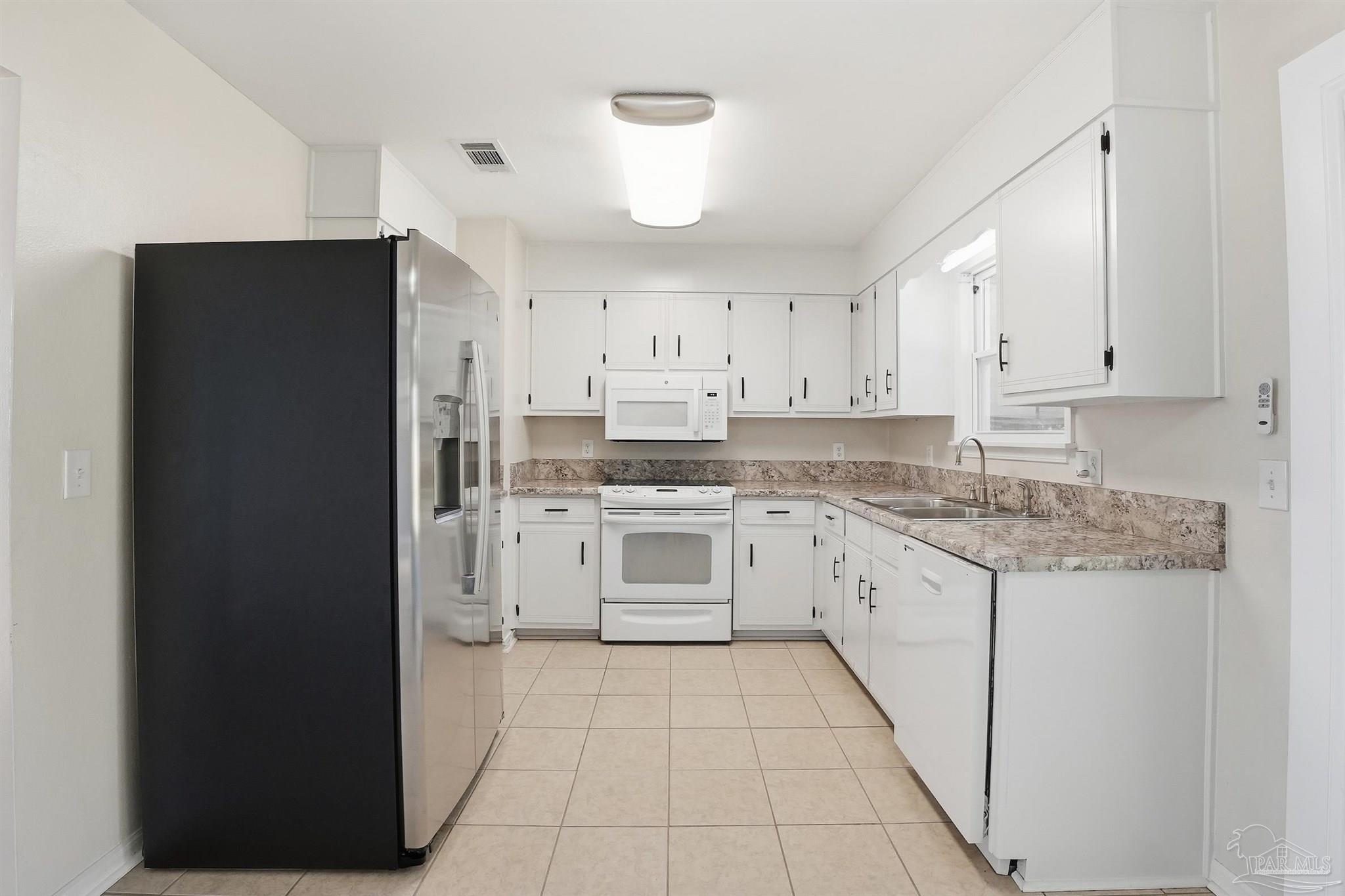 5590 Cyanamid Road Milton, FL 32583 - Photo 8 of 44 a kitchen with granite countertop white cabinets and stainless steel appliances