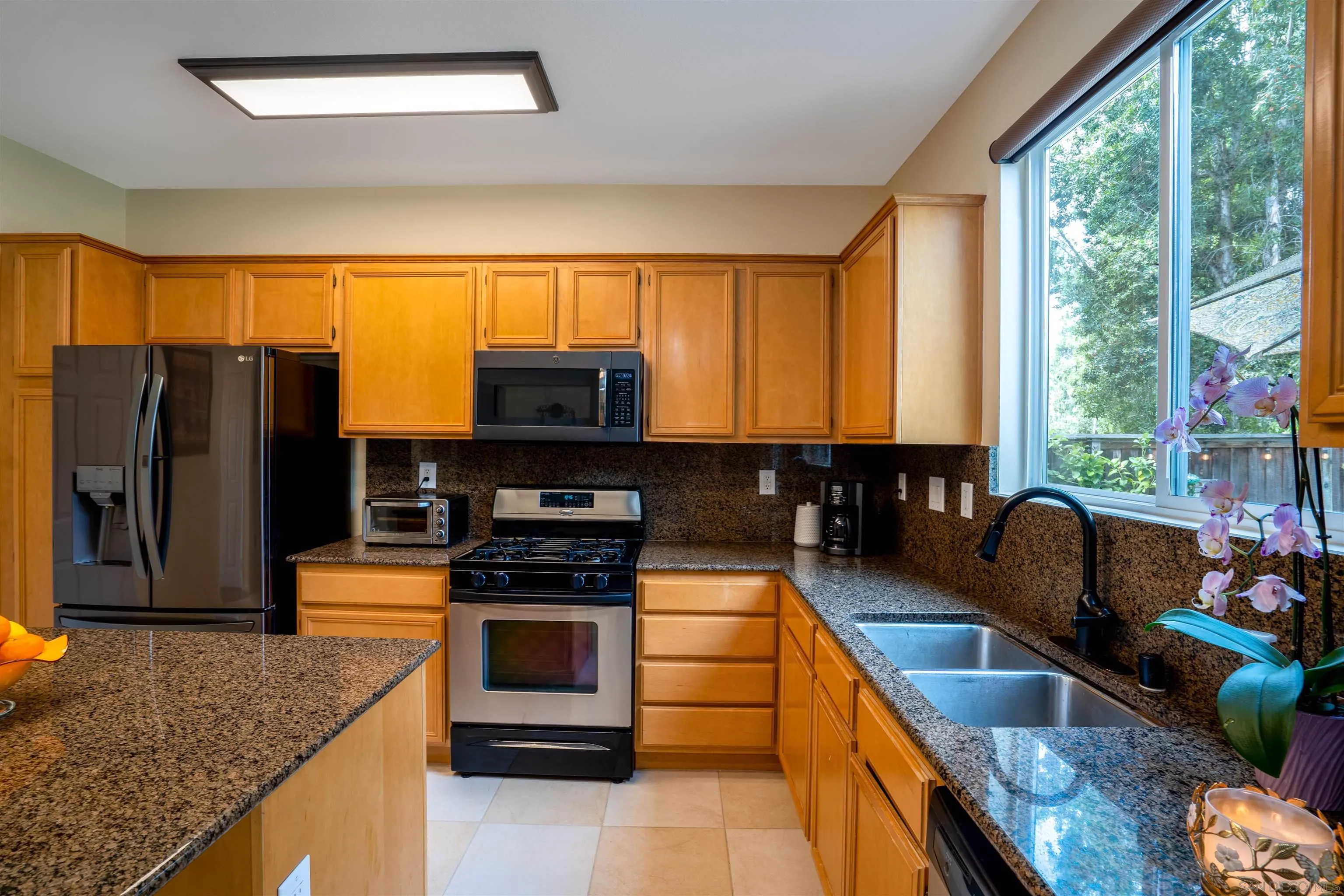38837 Rockinghorse Road Murrieta, CA 92563 - Photo 12 of 41 a kitchen with stainless steel appliances granite countertop a stove a sink and a microwave