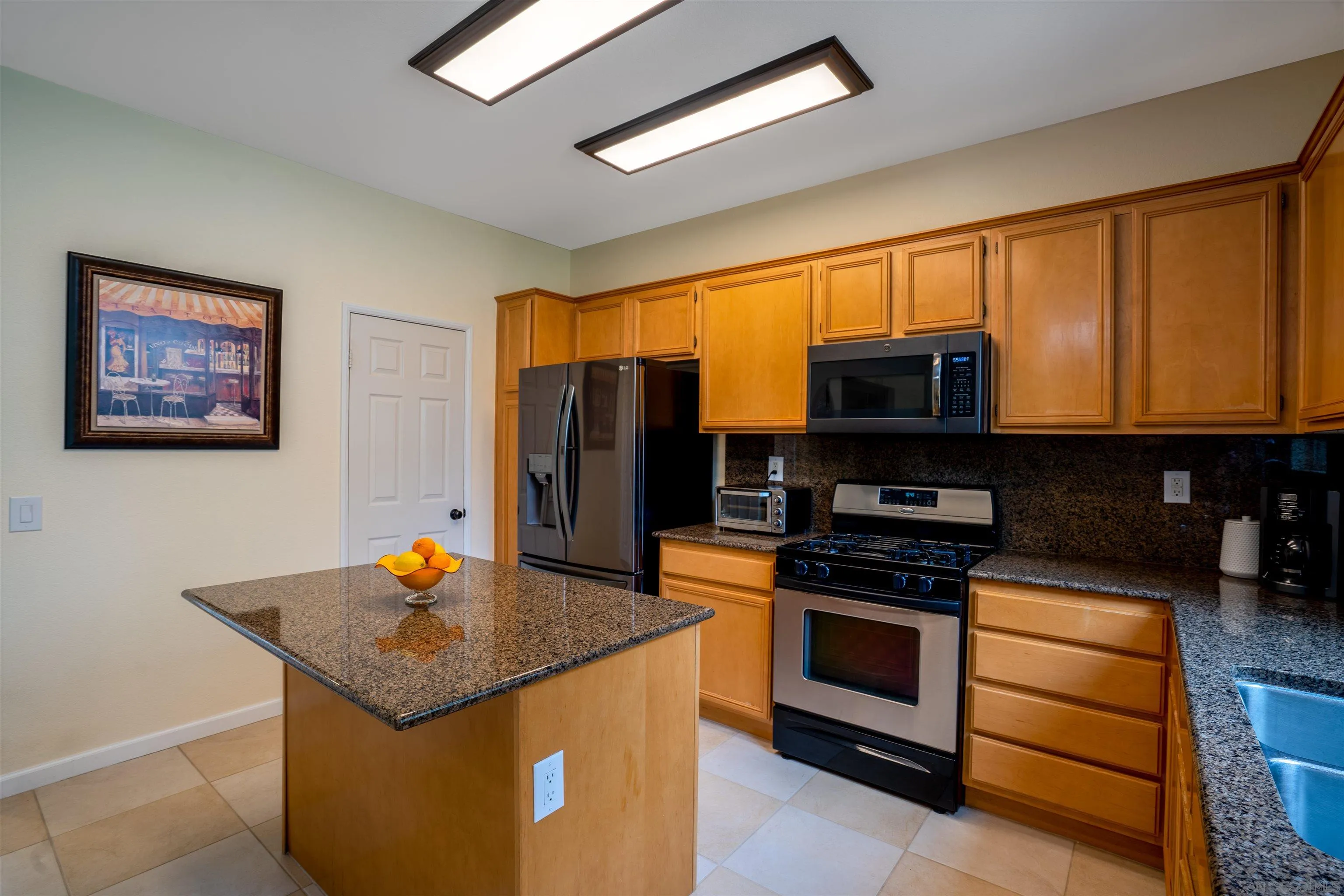 38837 Rockinghorse Road Murrieta, CA 92563 - Photo 13 of 41 a kitchen with stainless steel appliances a stove a microwave and a view of living room