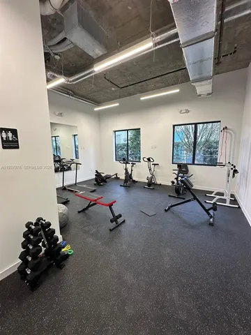 a living room with furniture and gym equipment