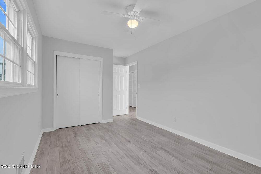 26 Mermaid Road Toms River, NJ 08753 - Photo 30 of 48 an empty room with wooden floor and windows