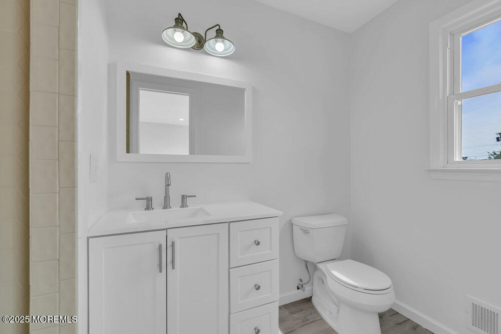 26 Mermaid Road Toms River, NJ 08753 - Photo 31 of 48 a bathroom with a toilet sink vanity and mirror