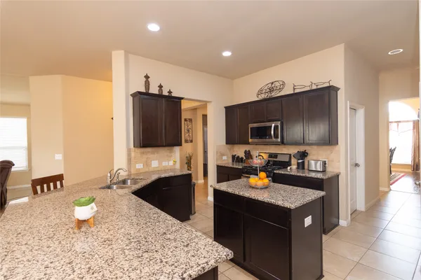 a kitchen with a stove a sink and a refrigerator