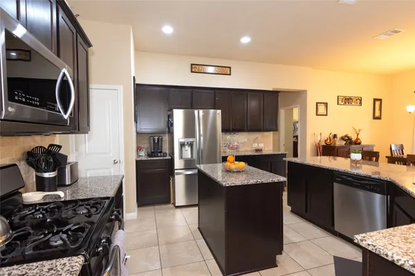 a kitchen with stainless steel appliances a sink stove and refrigerator