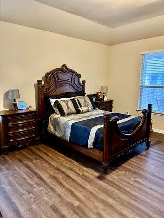 a bedroom with a bed and a potted plant on dresser