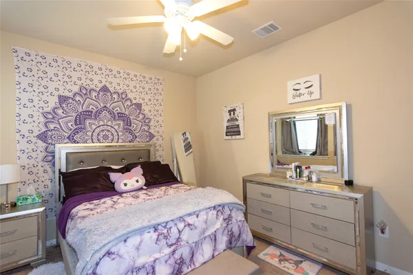 a bedroom with a bed and a mirror on the dresser