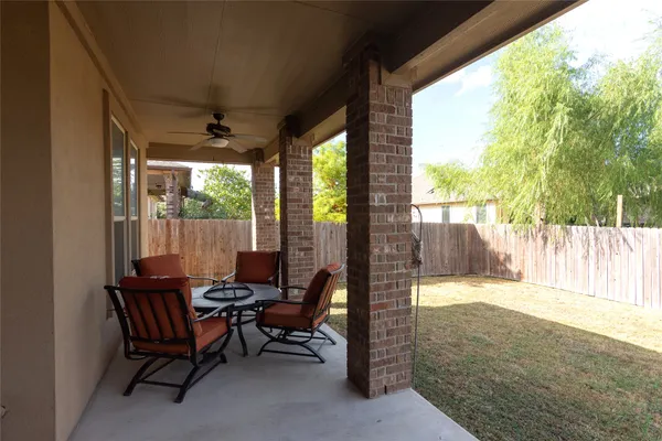 a living room with patio furniture and a floor to ceiling window