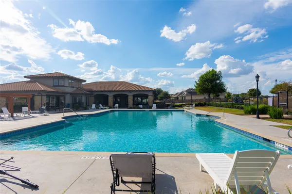 a view of a house with swimming pool having outdoor seating