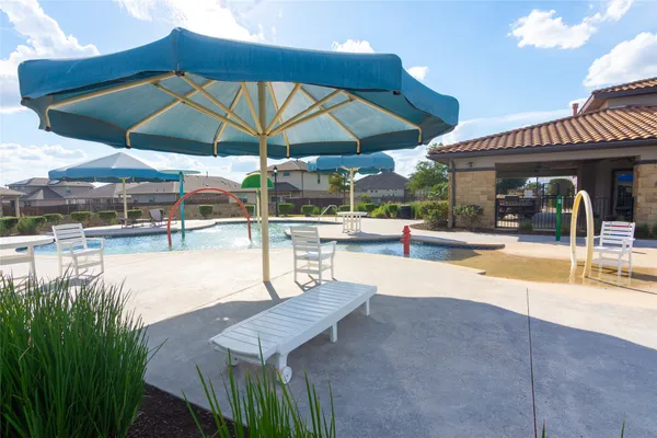a view of a swimming pool with chairs in patio