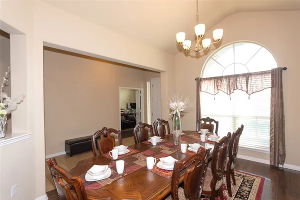 a view of a dining room with furniture wooden floor and chandelier
