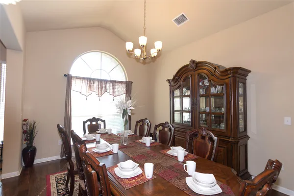 a view of a dining room with furniture a chandelier and wooden floor