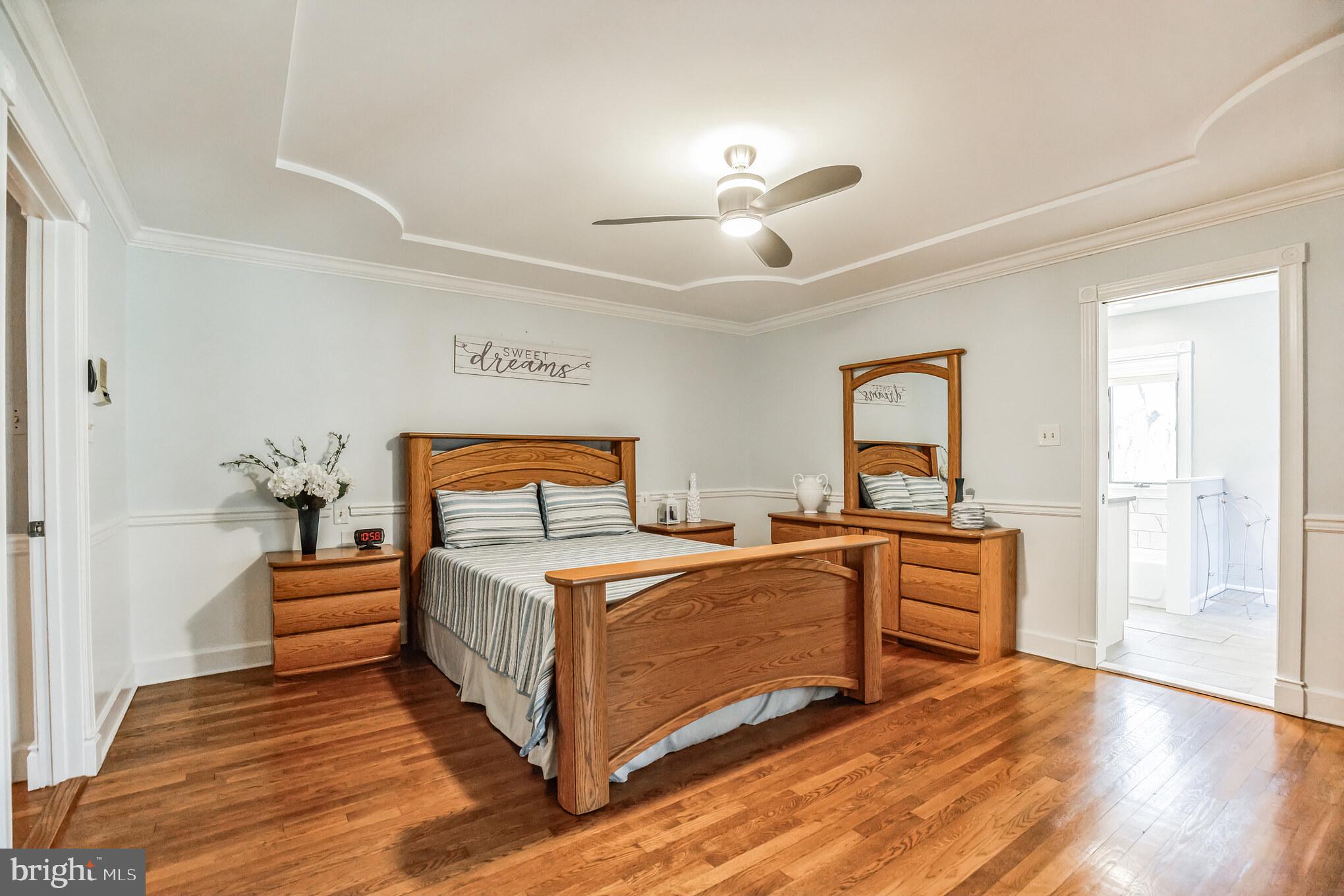 3310 Holland Cliffs Road Huntingtown, MD 20639 - Photo 30 of 40 a bedroom with a large bed and a chandelier