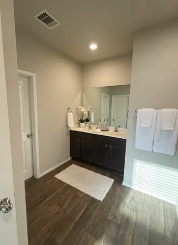 a en suite bathroom with a sink vanity and a mirror