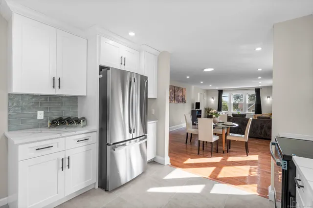 a kitchen with white cabinets and stainless steel appliances