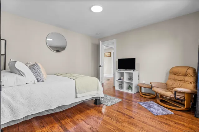 a bedroom with a bed and wooden floor