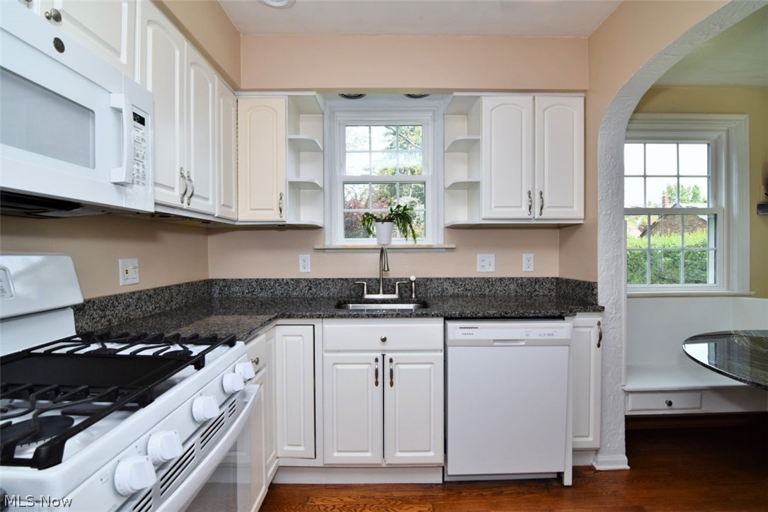 3451 Edison Road Cleveland Heights, OH 44121 - Photo 19 of 46 Kitchen featuring white cabinetry, dark speckled countertops, integrated microwave, and a built-in dishwasher