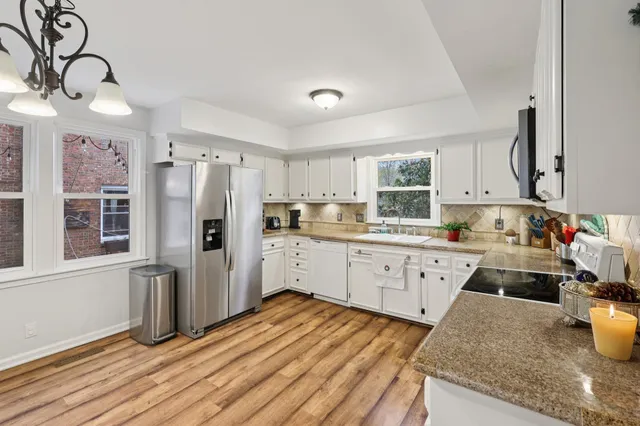 a kitchen with stainless steel appliances granite countertop a refrigerator sink and cabinets