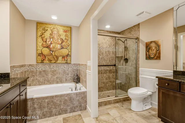 a bathroom with a granite countertop sink a toilet a large mirror and shower