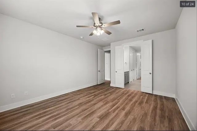 a view of an empty room with wooden floor