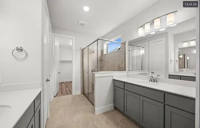 a spacious bathroom with a double vanity sink mirror double and shower