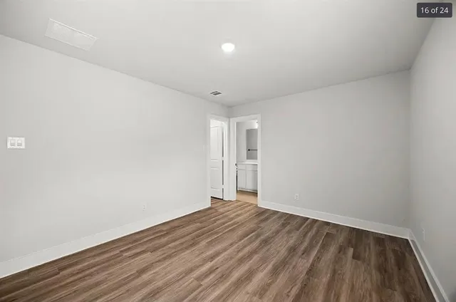 a view of empty room with wooden floor