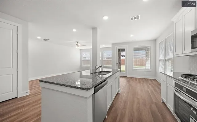 a kitchen with granite countertop a sink stove and refrigerator