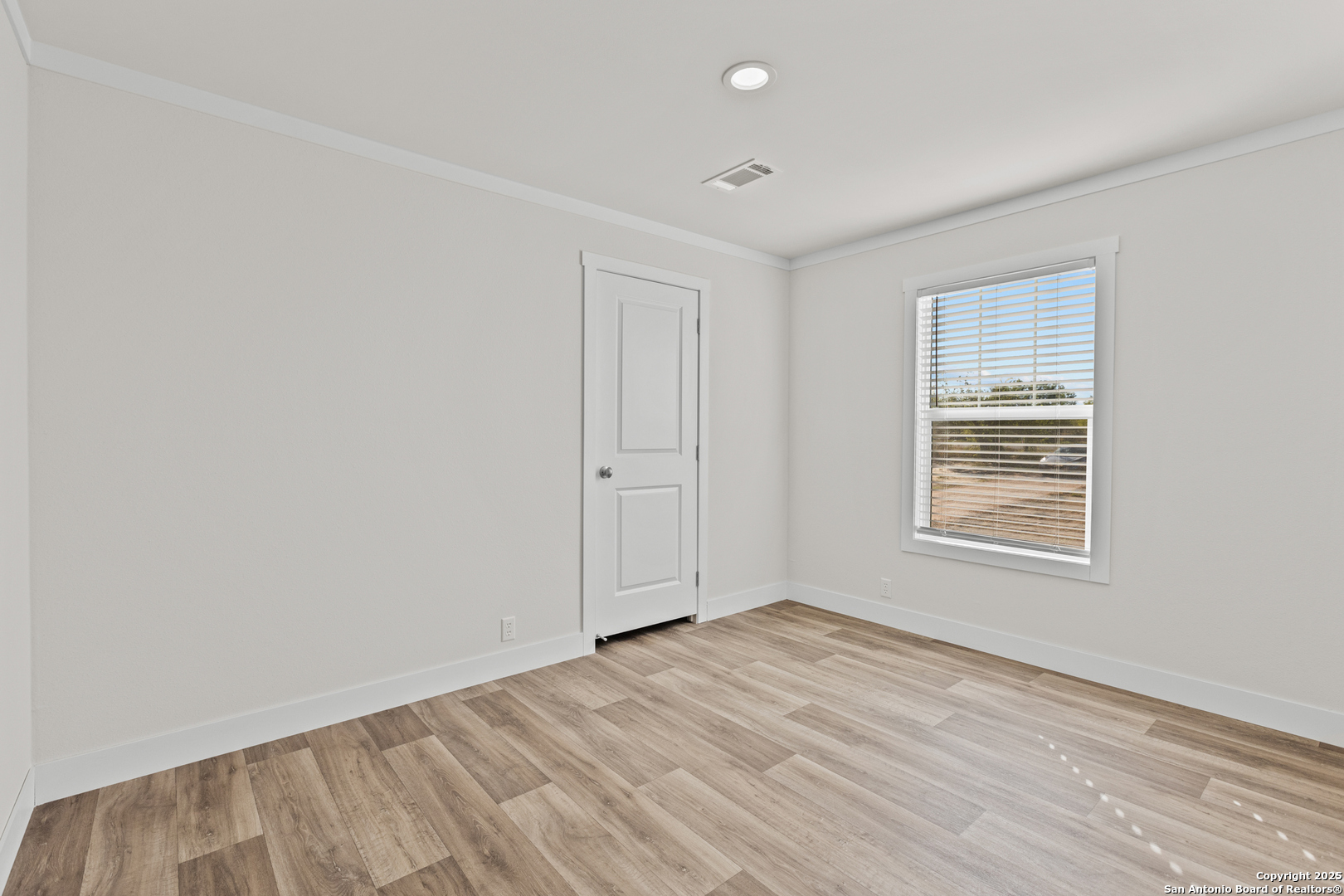 2354 Stevens Road Somerset, TX 78069 - Photo 17 of 22 an empty room with wooden floor and windows