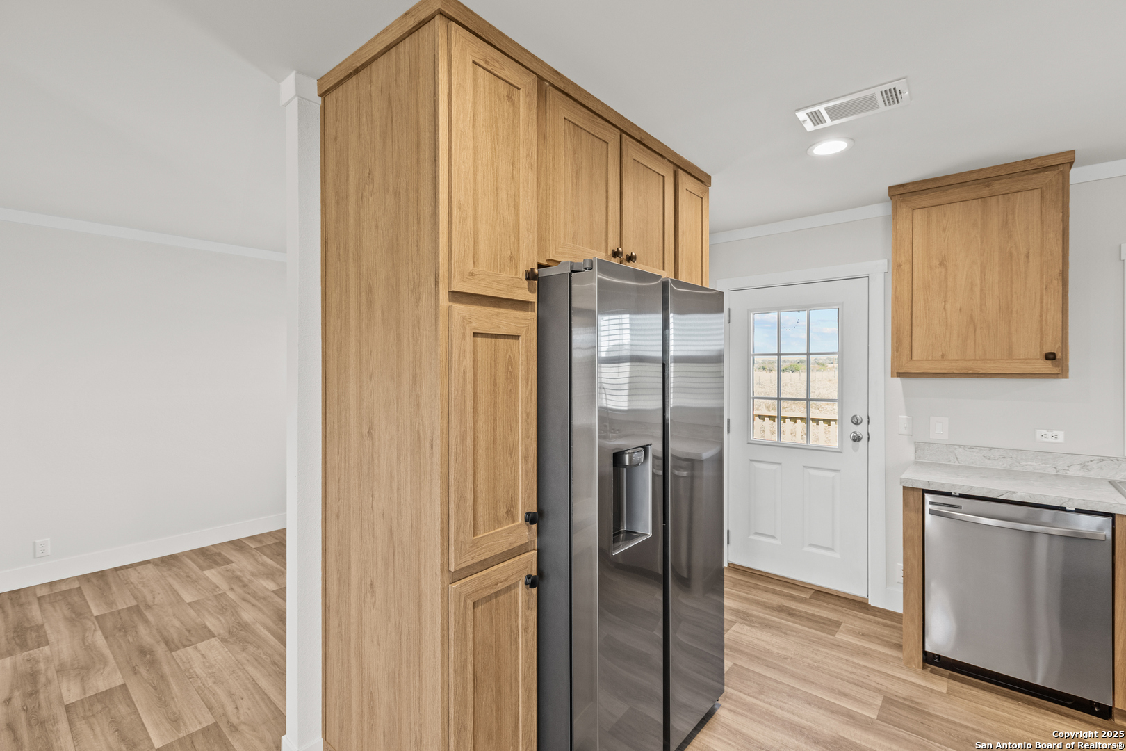 2354 Stevens Road Somerset, TX 78069 - Photo 7 of 22 a kitchen with stainless steel appliances a refrigerator and cabinets