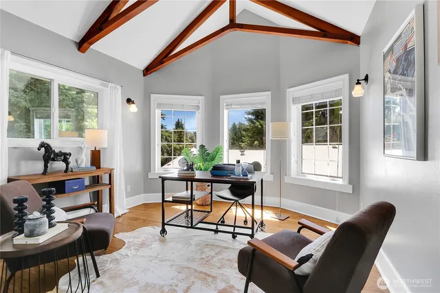 a living room with furniture a fireplace and large windows