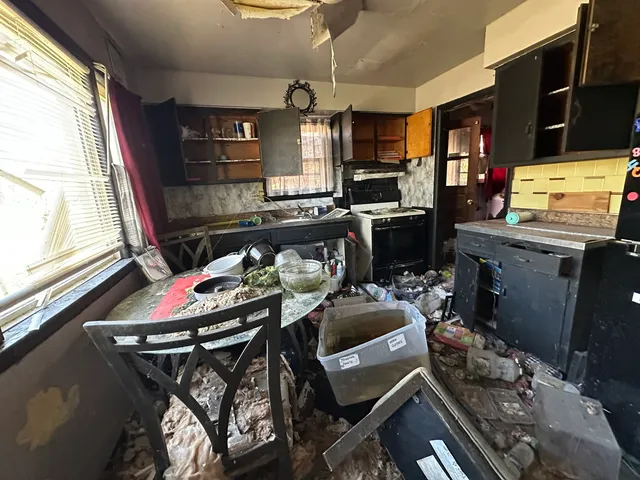 a kitchen with stainless steel appliances granite countertop a stove top oven a dining table and chairs with wooden floor