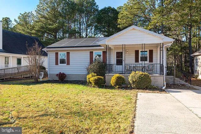 a view of a house with a large yard and large trees