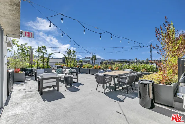 a view of a patio with dining table and chairs with plants