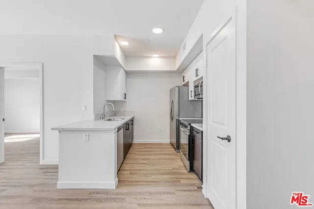 a kitchen with stainless steel appliances granite countertop a sink and a refrigerator
