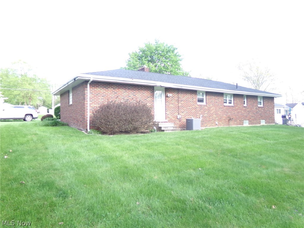 1912 Pickle Road Akron, OH 44312 - Photo 2 of 26 Back of house with a yard and central air condition unit