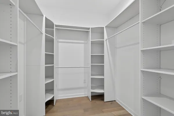 a view of walk in closet with empty racks