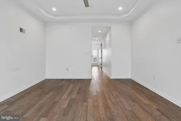 a view of an empty room with wooden floor
