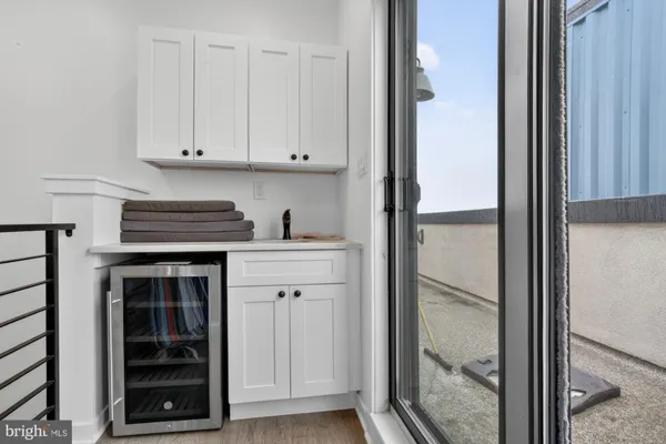 a kitchen with a refrigerator and white cabinets